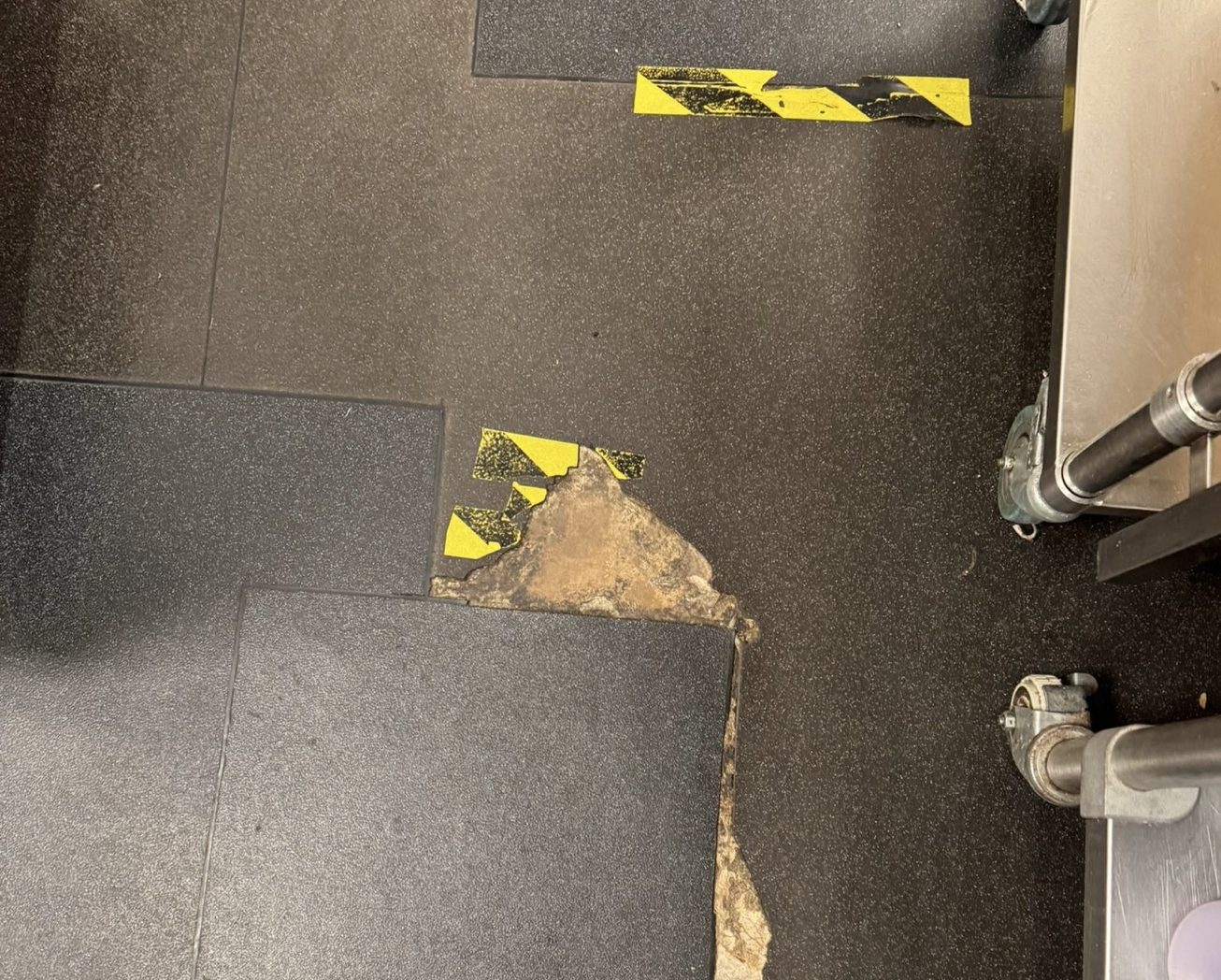 Failed safety vinyl flooring in a commercial environment requiring repair before replacement.